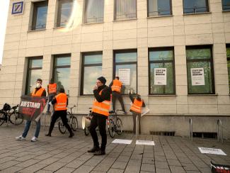 Aktivistis kleistern Denkzettel an die Fassade der Deutschen Bank