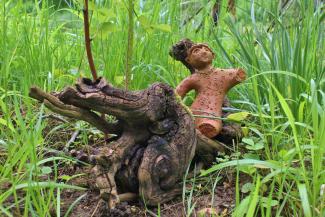 Tonfigur auf Wurzel