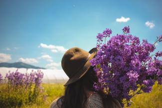 Eine Gärtnerin mit Hut und Blumen auf einem Feld